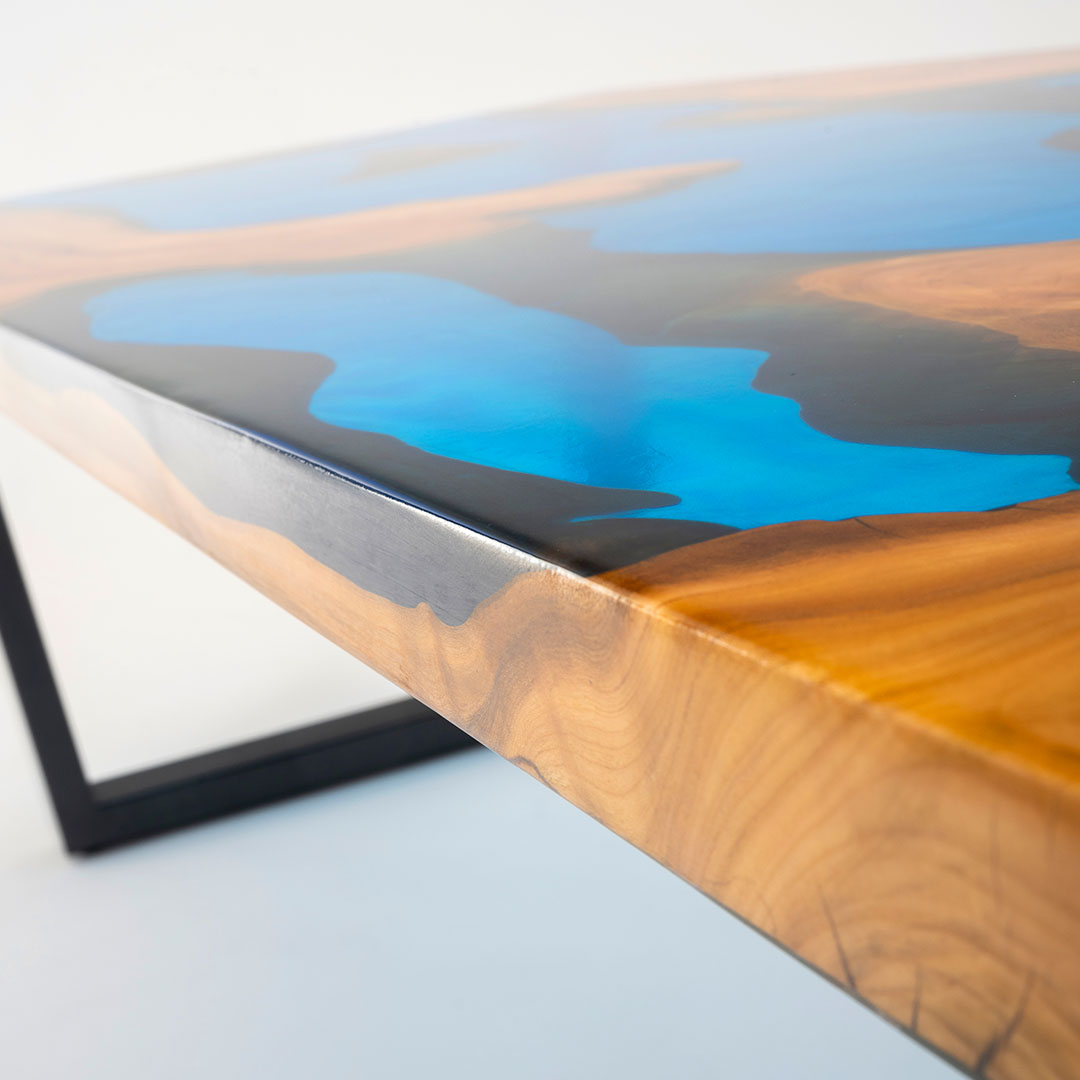 Close up of a cherry and aqua resin river table